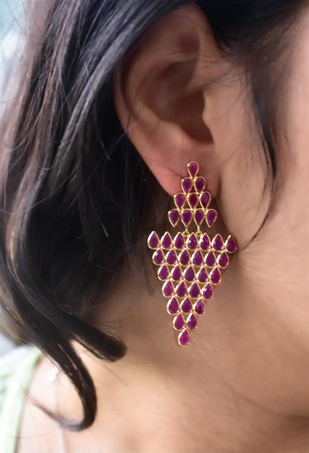 Model wearing a ruby chandelier earring, side profile lifestyle jewellery shot
